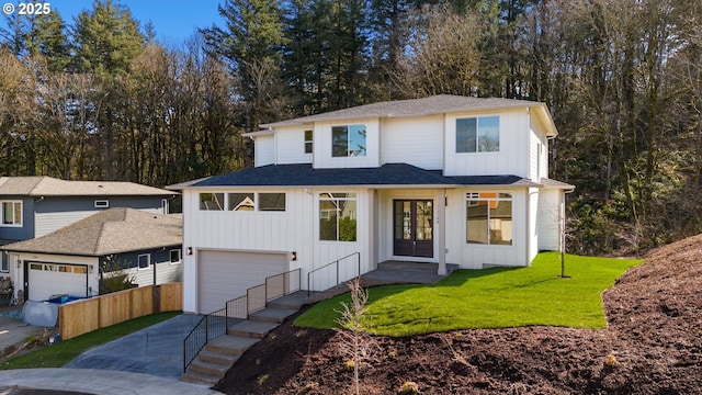 modern farmhouse featuring a garage, driveway, board and batten siding, and a front yard