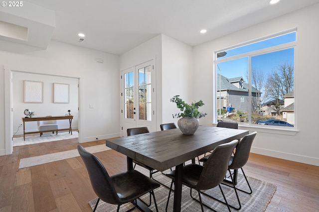 dining room with baseboards, light wood finished floors, and recessed lighting