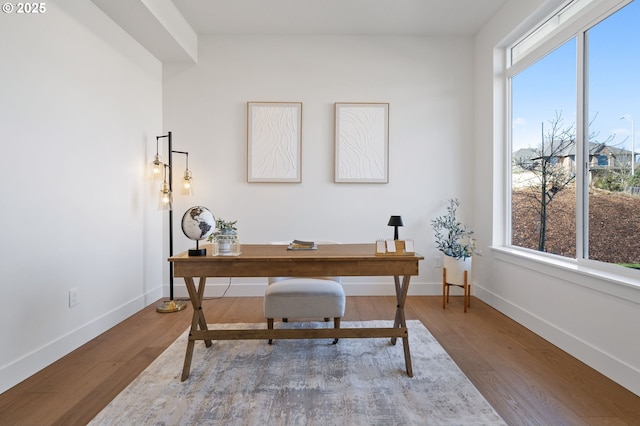 home office with baseboards and wood finished floors