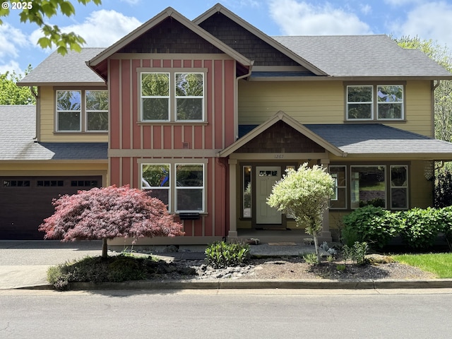 view of front of home featuring a garage, board and batten siding, a shingled roof, and driveway