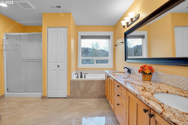 full bath featuring a garden tub, a sink, visible vents, a closet, and double vanity