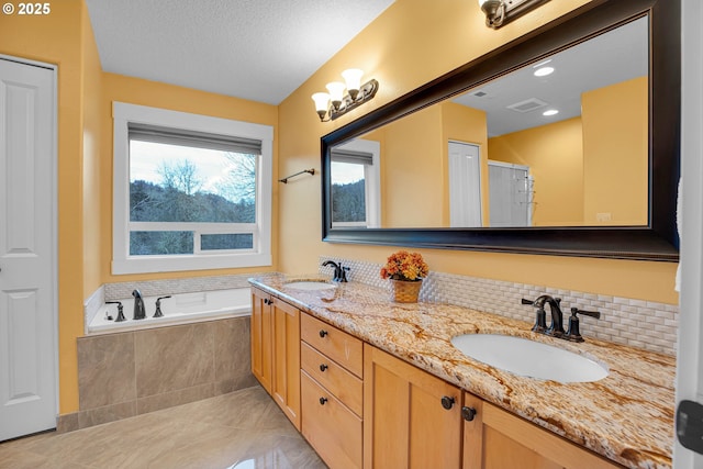 bathroom featuring visible vents, a sink, decorative backsplash, and a bath