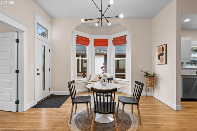 dining room with a chandelier, light wood-type flooring, and a wealth of natural light