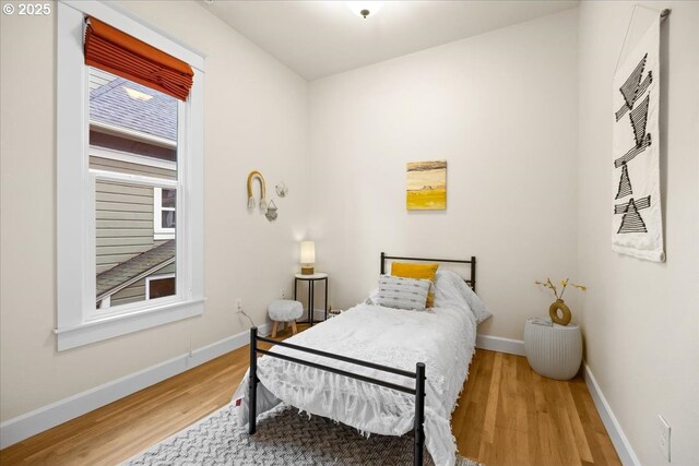 bedroom featuring multiple windows, ceiling fan, and light hardwood / wood-style flooring