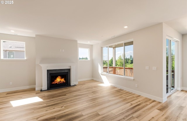 17437 NW Antonio St, Portland, OR 97229 - unfurnished living room with wood finished floors, a fireplace with flush hearth, baseboards, and recessed lighting