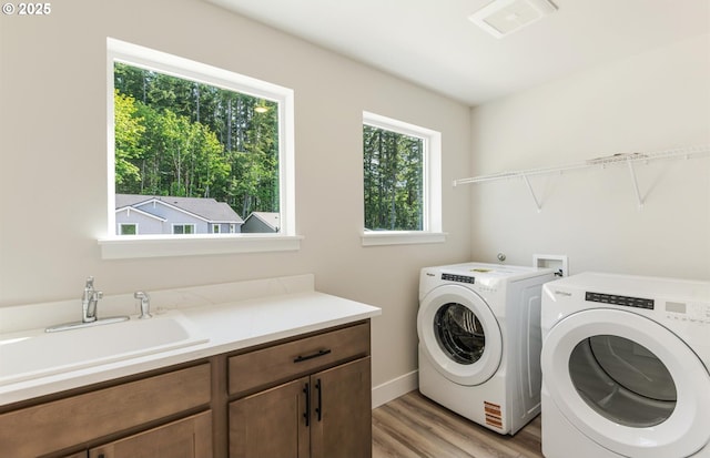 17437 NW Antonio St, Portland, OR 97229 - laundry room featuring cabinet space, washer and clothes dryer, light wood finished floors, and baseboards