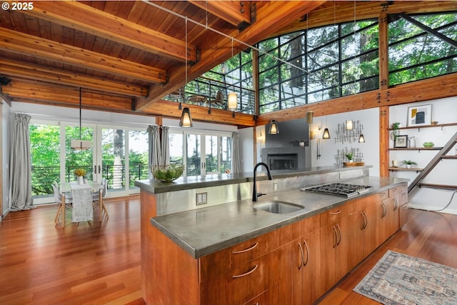 4183 SW Greenleaf Dr, Portland, OR 97221 - kitchen with a sink, stainless steel gas cooktop, wood finished floors, wood ceiling with exposed beams, and a center island with sink