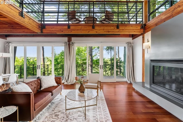 4183 SW Greenleaf Dr, Portland, OR 97221 - living room featuring wood finished floors, french doors, a high ceiling, beam ceiling, and a glass covered fireplace