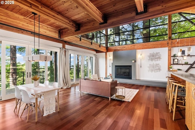 4183 SW Greenleaf Dr, Portland, OR 97221 - living room with wood finished floors, wooden ceiling with exposed beams, a glass covered fireplace, and a towering ceiling