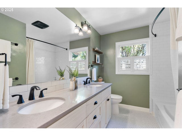 full bathroom with a sink, tile patterned flooring, toilet, and double vanity