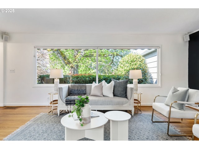 living area with visible vents, baseboards, and wood finished floors