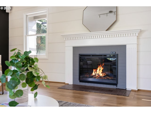 interior details featuring a decorative wall, baseboards, wood finished floors, and a tile fireplace