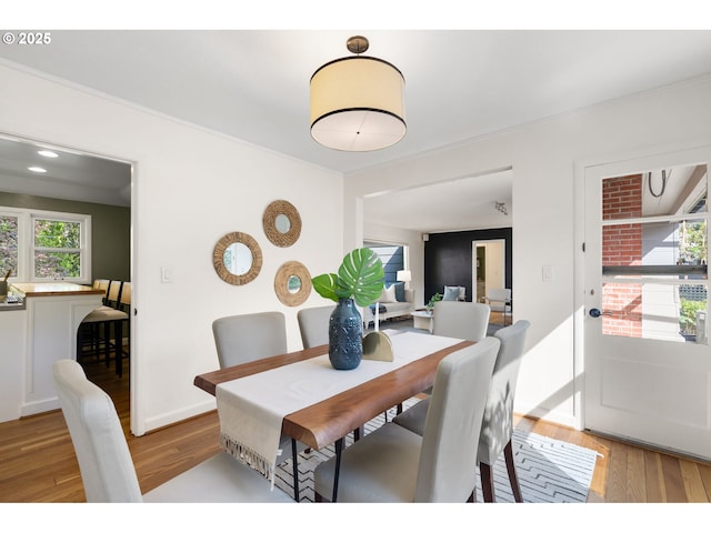dining room with crown molding and wood finished floors