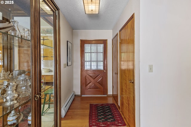 16828 Webster Rd, Gladstone, OR 97027 - doorway featuring a baseboard radiator, light wood-style floors, and a textured ceiling