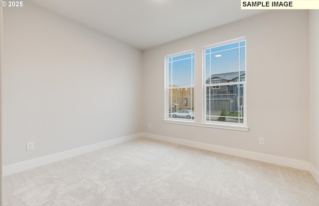 spare room featuring carpet and baseboards