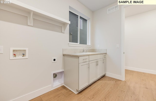 washroom with electric dryer hookup, washer hookup, light wood-style flooring, and baseboards