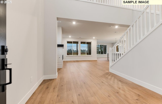 foyer entrance featuring stairway, light wood-style floors, baseboards, and recessed lighting