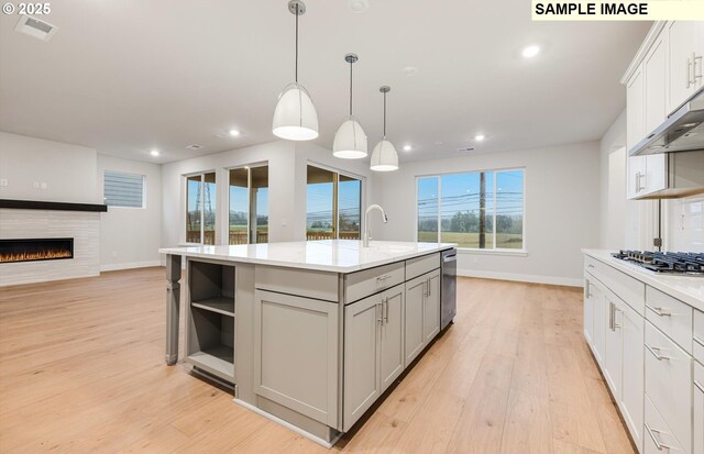 kitchen with gray cabinets, stainless steel appliances, light wood-type flooring, open shelves, and baseboards