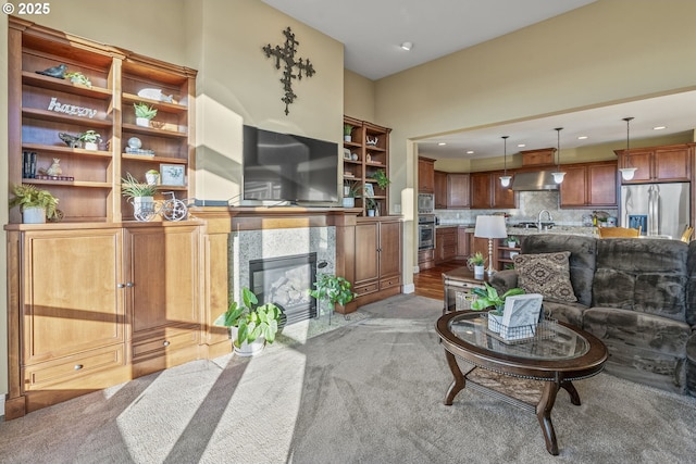 living room with a fireplace, sink, and light carpet