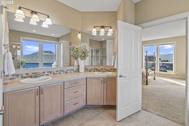 bathroom with tile patterned flooring, a water view, vanity, decorative backsplash, and walk in shower