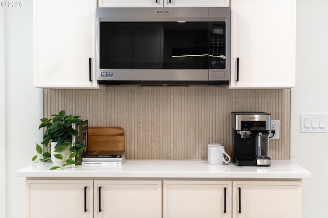 18560 Lower Midhill Dr, West Linn, OR 97068 - detailed view of stainless steel microwave, white cabinetry, and decorative backsplash