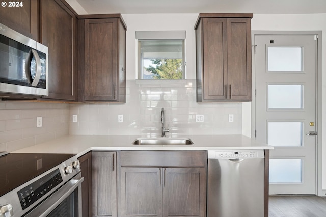 kitchen featuring decorative backsplash, sink, dark brown cabinetry, and stainless steel appliances