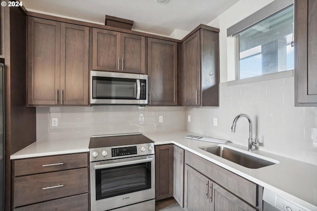 kitchen with tasteful backsplash, appliances with stainless steel finishes, sink, and dark brown cabinets