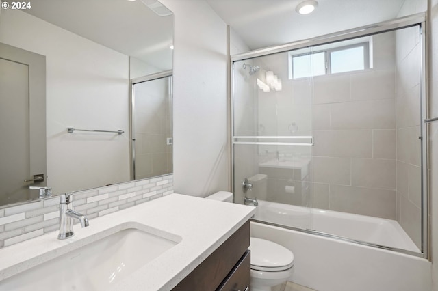 full bathroom with toilet, vanity, decorative backsplash, and shower / bath combination with glass door