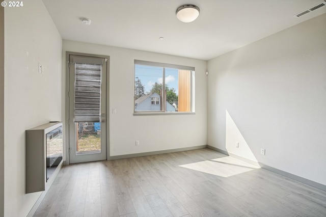 unfurnished room featuring a healthy amount of sunlight and light hardwood / wood-style flooring