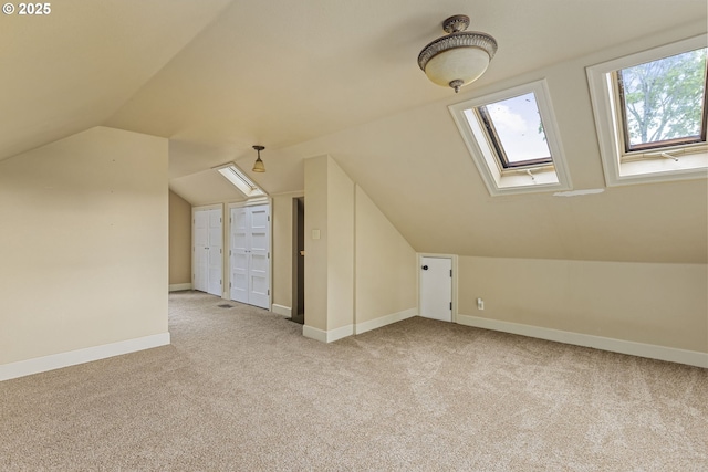 additional living space featuring carpet, vaulted ceiling, baseboards, and a skylight