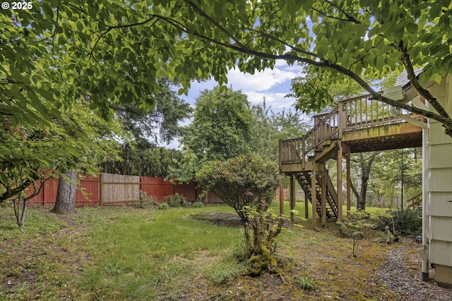 view of yard featuring fence, stairway, and a wooden deck