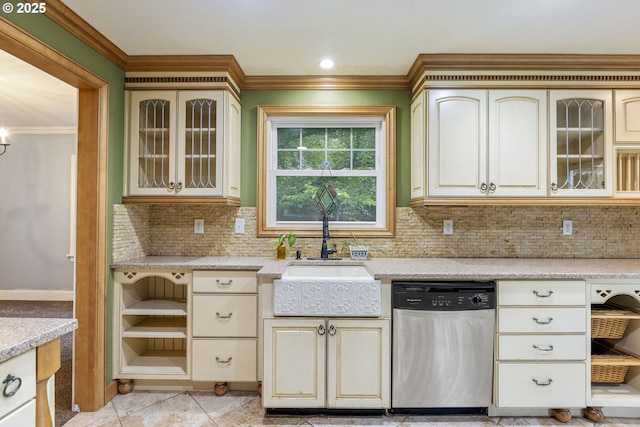 kitchen featuring stainless steel dishwasher, a sink, ornamental molding, cream cabinetry, and decorative backsplash
