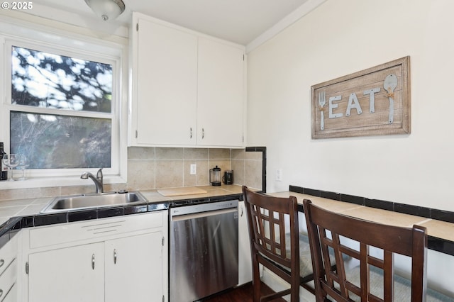 kitchen with sink, dishwasher, white cabinetry, tile counters, and decorative backsplash