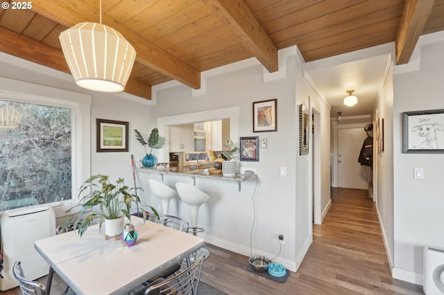 dining area featuring wood ceiling, beam ceiling, and hardwood / wood-style flooring