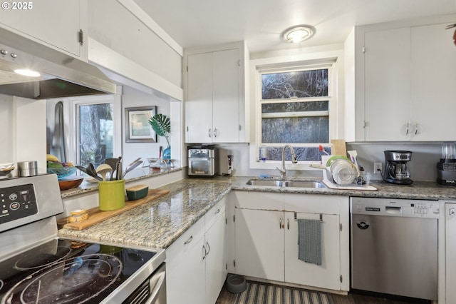 kitchen with stainless steel appliances, sink, white cabinets, and light stone counters