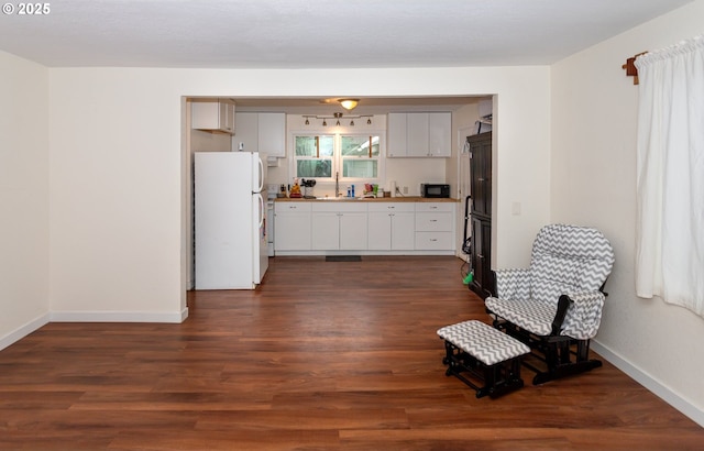 166 Iowa St, Eugene, OR 97402 - kitchen with freestanding refrigerator, dark wood-type flooring, white cabinetry, and black microwave