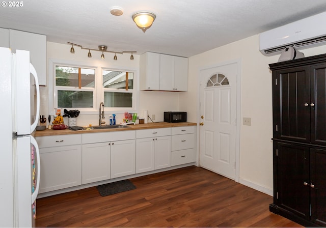 166 Iowa St, Eugene, OR 97402 - kitchen featuring freestanding refrigerator, a wall mounted air conditioner, dark wood finished floors, white cabinetry, and wood counters