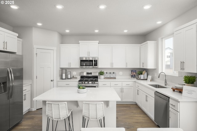 5603 Edward Ct SE, Albany, OR 97322 - kitchen with stainless steel appliances, a kitchen island, dark wood-style floors, white cabinetry, and recessed lighting