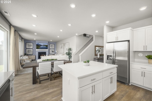 5603 Edward Ct SE, Albany, OR 97322 - kitchen with appliances with stainless steel finishes, light wood-type flooring, recessed lighting, white cabinets, and a kitchen island