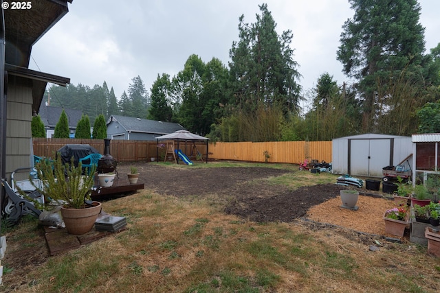 1727 E Washington Ave, Cottage Grove, OR 97424 - fenced backyard featuring a storage unit, a playground, and a vegetable garden