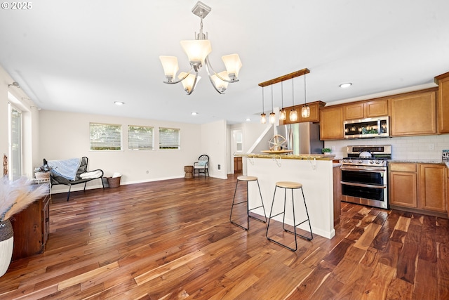 1225 3rd Ave, Hammond, OR 97121 - kitchen with appliances with stainless steel finishes, a chandelier, open floor plan, brown cabinetry, and dark wood-style floors
