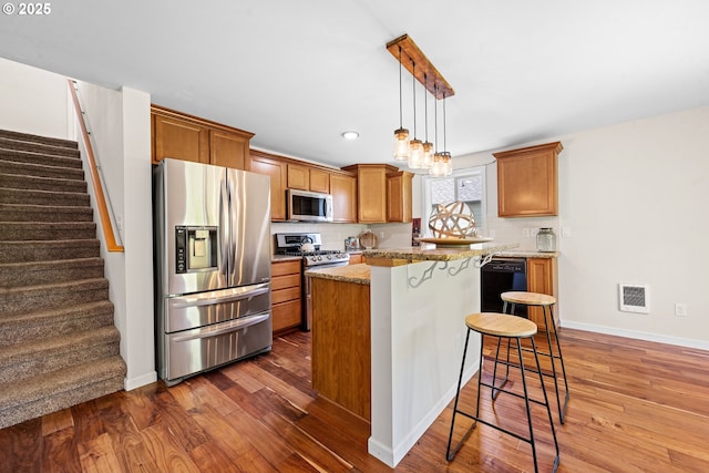 1225 3rd Ave, Hammond, OR 97121 - kitchen with appliances with stainless steel finishes, dark wood-style floors, backsplash, a breakfast bar area, and a center island