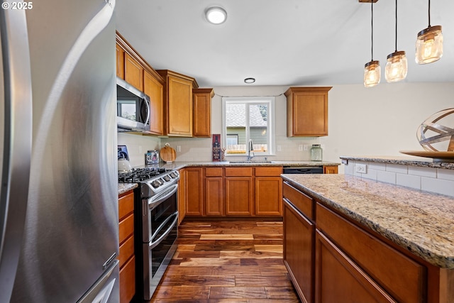 1225 3rd Ave, Hammond, OR 97121 - kitchen featuring appliances with stainless steel finishes, a sink, dark wood-style floors, and brown cabinetry