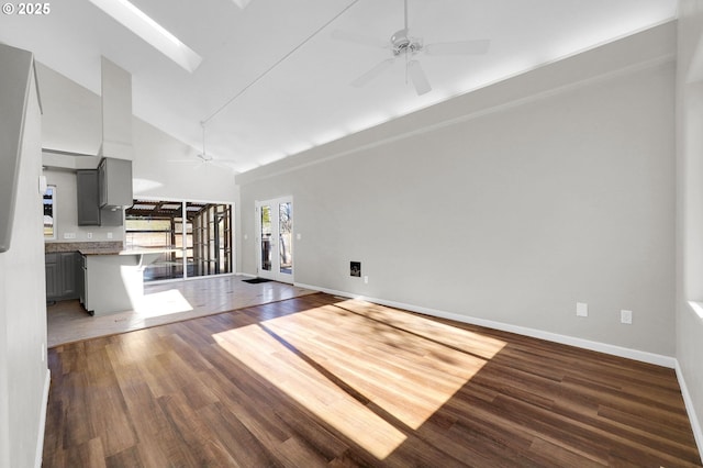 unfurnished living room featuring ceiling fan, a skylight, high vaulted ceiling, and wood-type flooring