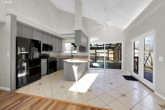 kitchen with gray cabinetry, light tile patterned flooring, french doors, and black appliances