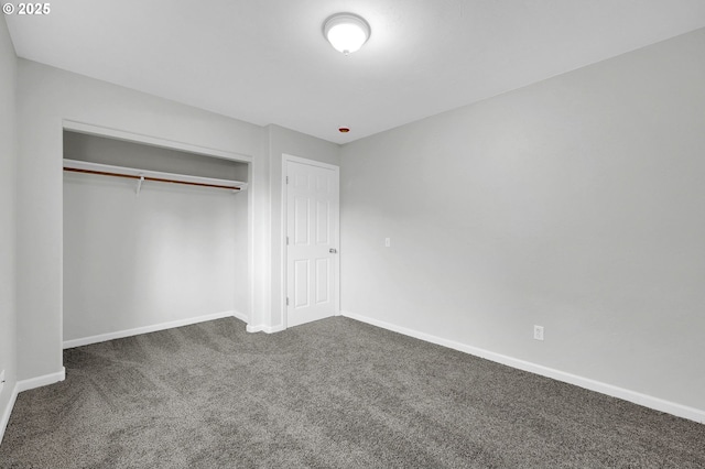 unfurnished bedroom featuring a closet and dark colored carpet