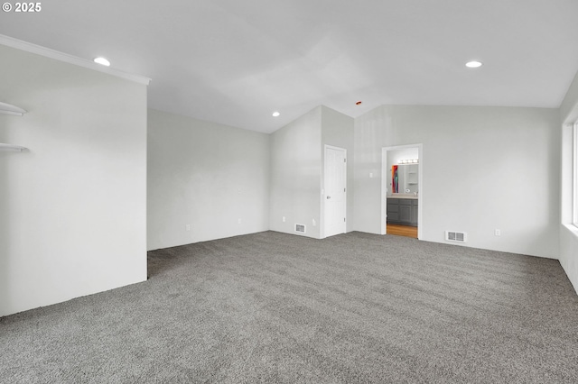 unfurnished bedroom featuring lofted ceiling, connected bathroom, and carpet