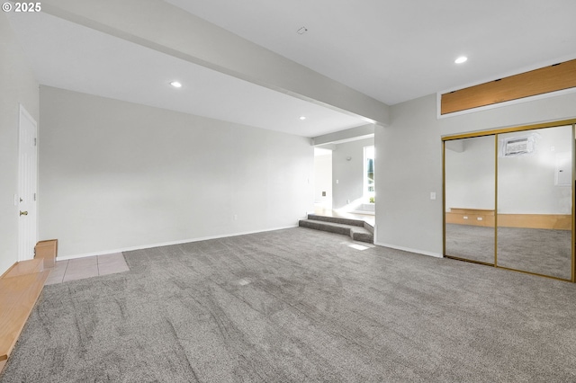 unfurnished living room with light colored carpet and beam ceiling