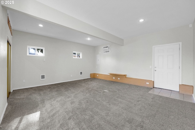 carpeted empty room with beamed ceiling and an AC wall unit