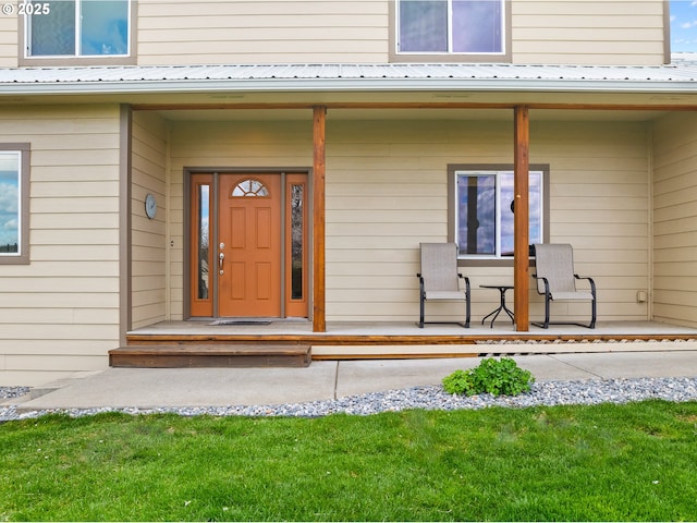 property entrance featuring a porch and metal roof